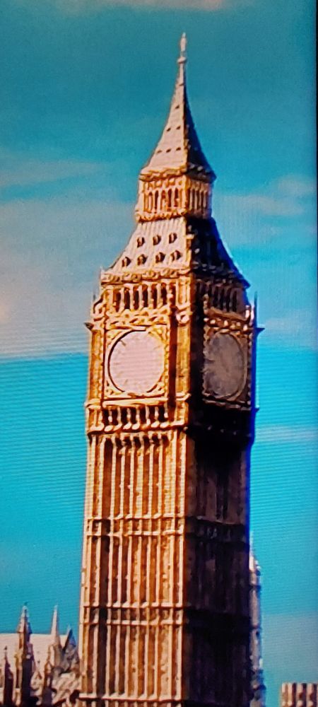 Elizabeth tower, (two faces in view, the main south face in sunshine and the east face in shadow) from the BBCTV News image, showing a beige circle where the ornate clock face should be.