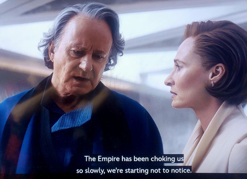 Stella Skarsgård as Luthen Rael, explaining why the rebellion needs to act, to Senator Mon Mothma, played by Genevieve O'Reilly. Caption: the Empire has been choking us so slowly, we're starting not to notice. 