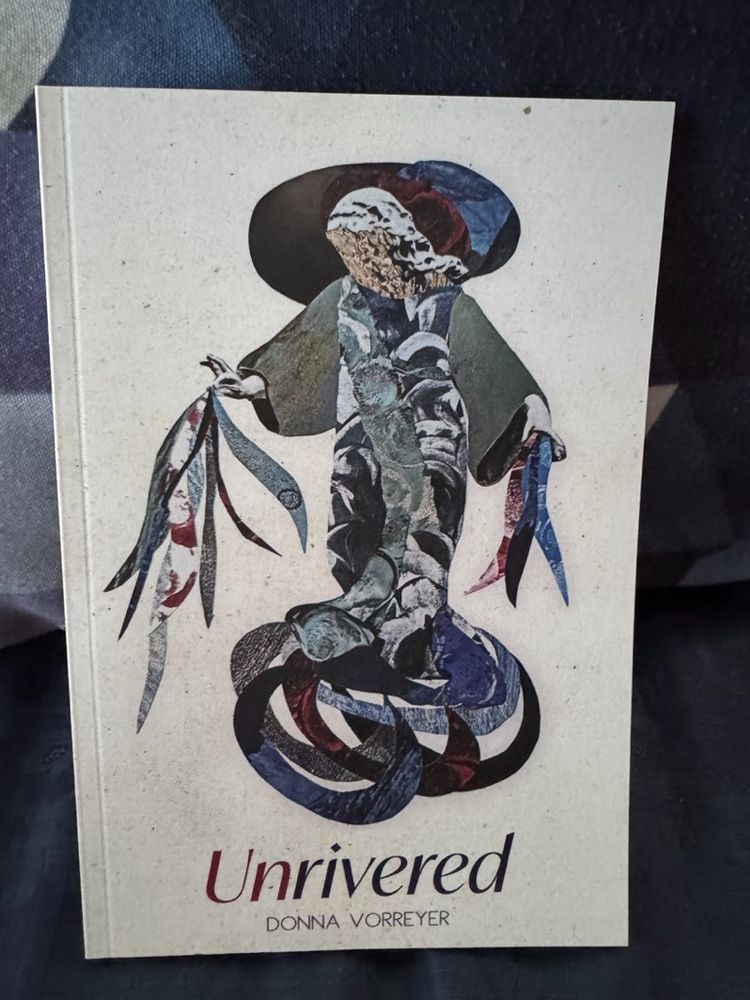 Photo of the book Unrivered by Donna Vorreyer on blue fabric 