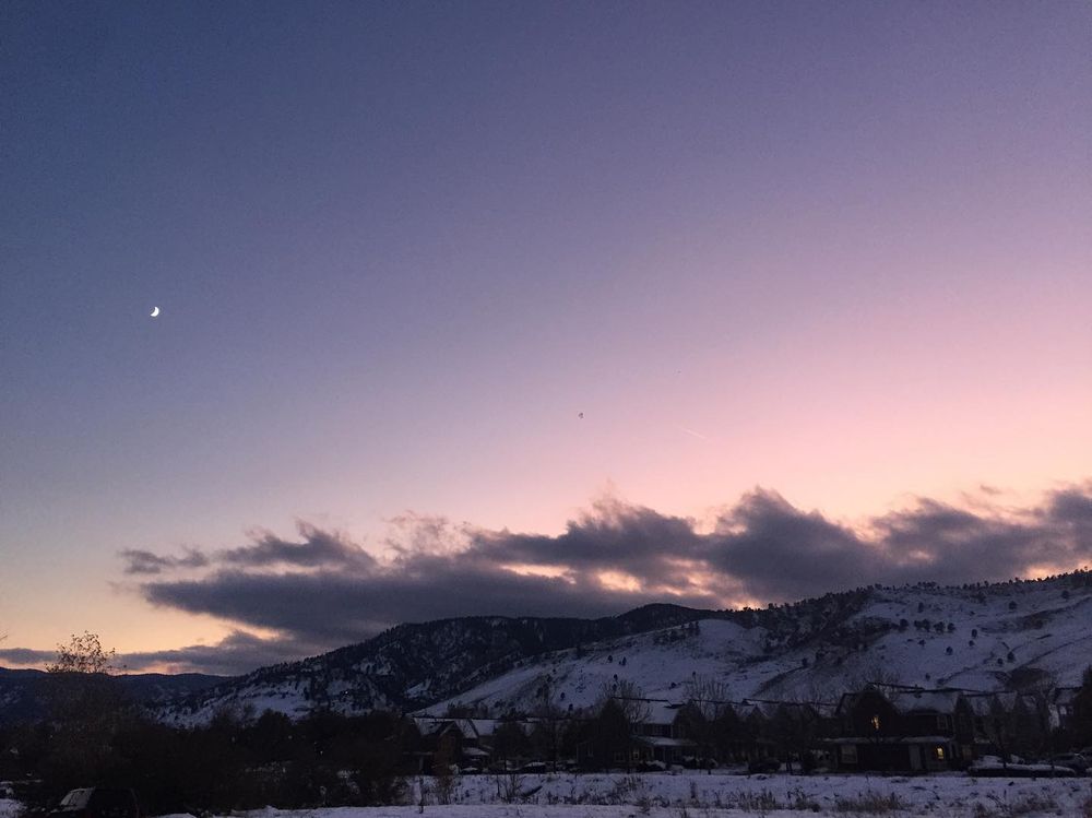 twilight snow-covered mountainscape with cloud and fragment of moon