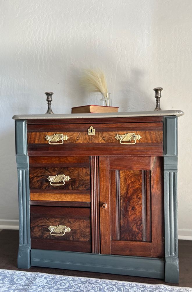 Newly refinished wash stand from the 18000s. The top and sides are repaired and painted. The figured wood drawers and cabinet door are repaired and renewed with finishing oil. The handles of the drawers are now clean and polished.