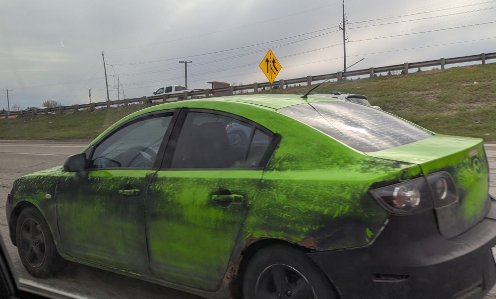 A green & grey Mazda.