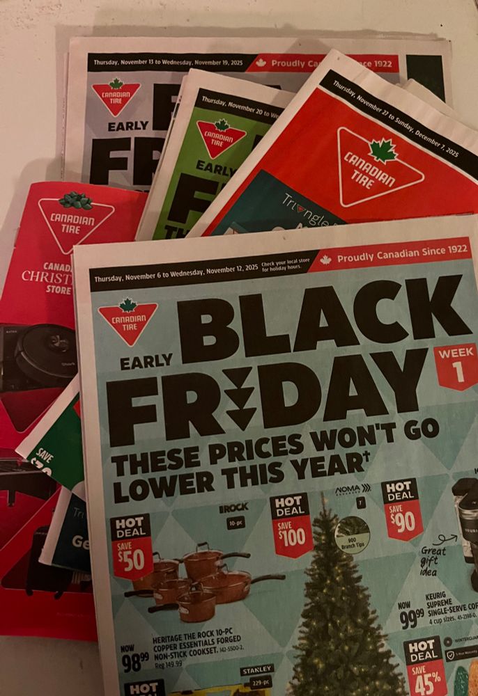 5 different Canadian Tire flyers stacked on a surface.  They’re all labelled Black Friday, pre-Black Friday, or Early Black Friday.  