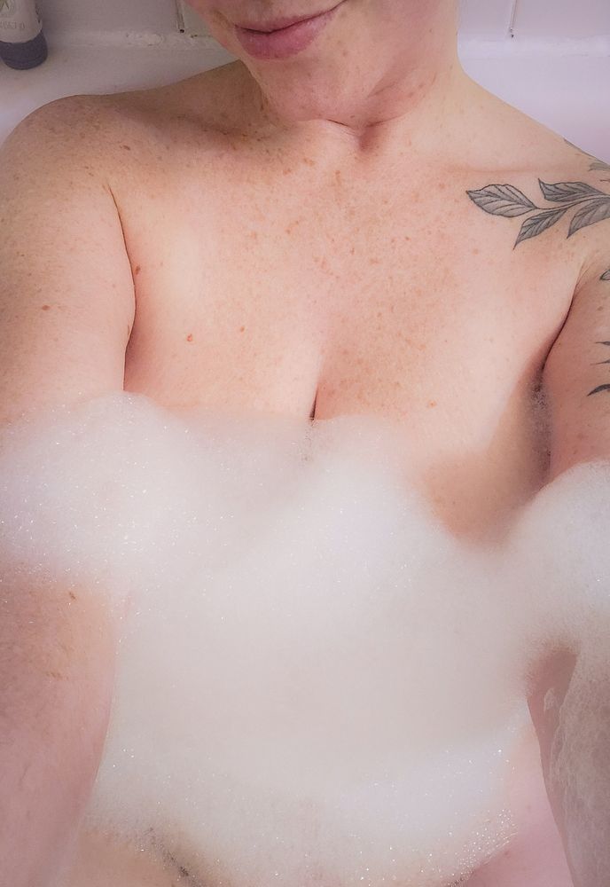 Lexy, naked in a bathtub only covered in bubbles. 