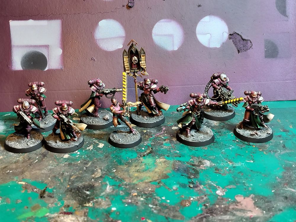 Painted squad of warhammer 40,000 Sisters of battle. Burgundy armour, green and scheme cloaks. 