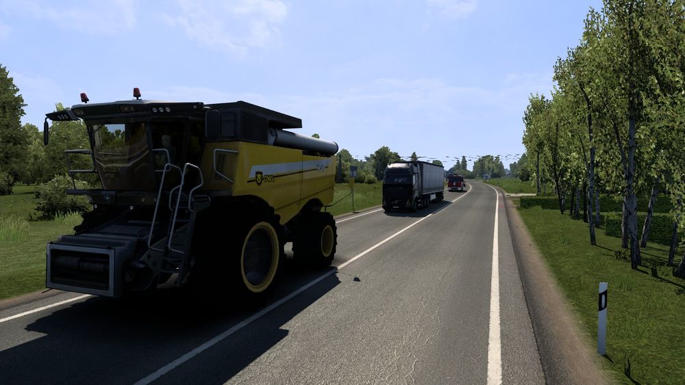A picture from within European Truck Simulator 2(ETS2) of my truck and trailer driving behind a slow moving Harvester.