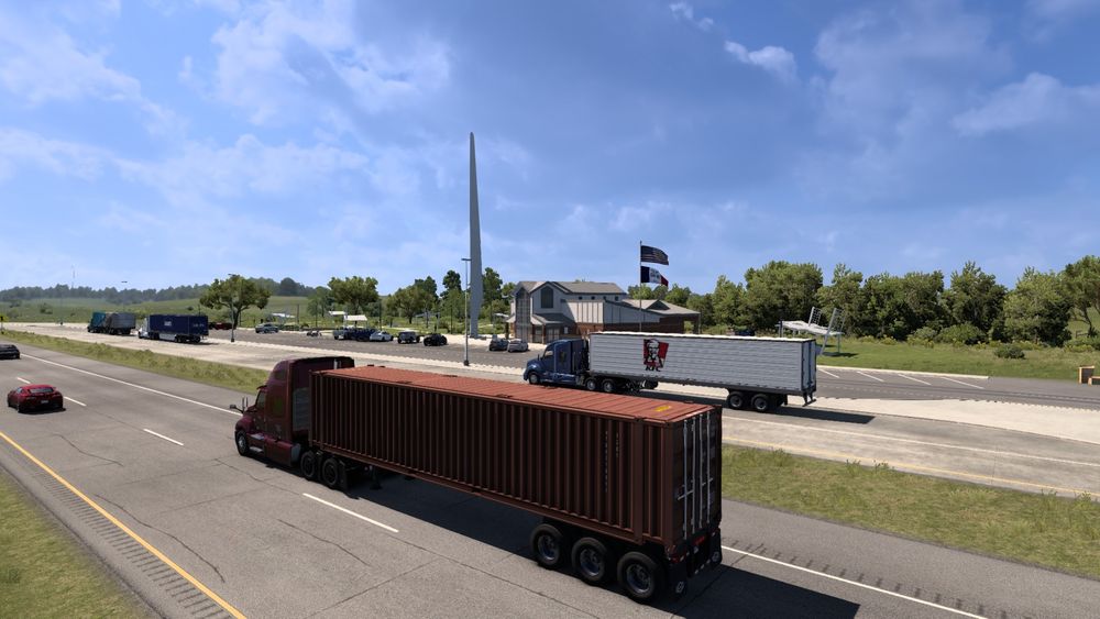 A picture from within American Truck Simulator(ATS) of my truck and trailer driving by a truck stop.