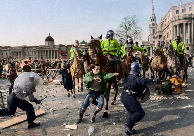Riot police on horseback barrel into protestors.