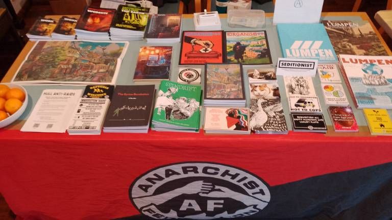 AF merch table full of zines and posters 
