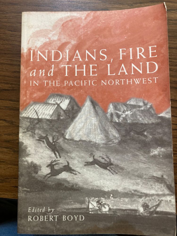 Book cover of Indians, Fire and the Land in the Pacific Northwest, edited by Robert Boyd. The cover features a painting of Indigenous camps with tipis and figures, deer in motion, and a red sky filled with smoke, evoking traditional fire stewardship of the land.