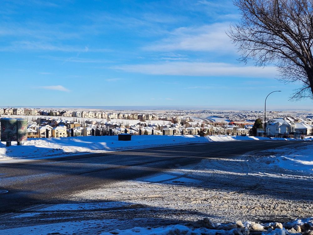 Another view across Edgemont Ravine, with Country Hills Blvd winding between MacEwan Glen and Hidden Valley in the distance