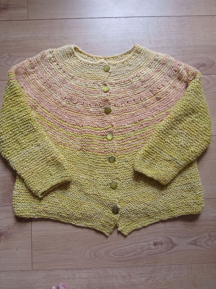 Yellow cardigan in garter stitch with round yoke in paler yellow and apricot colours.