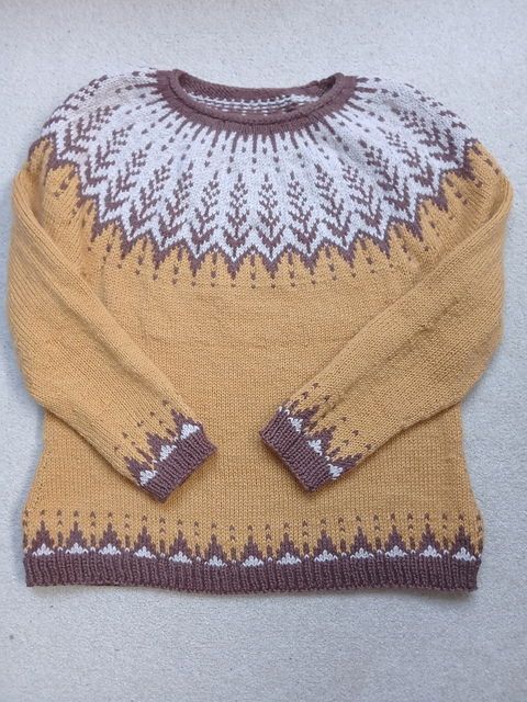 Golden yellow sweater with yoke in an ears of wheat design in brown on a white background. 