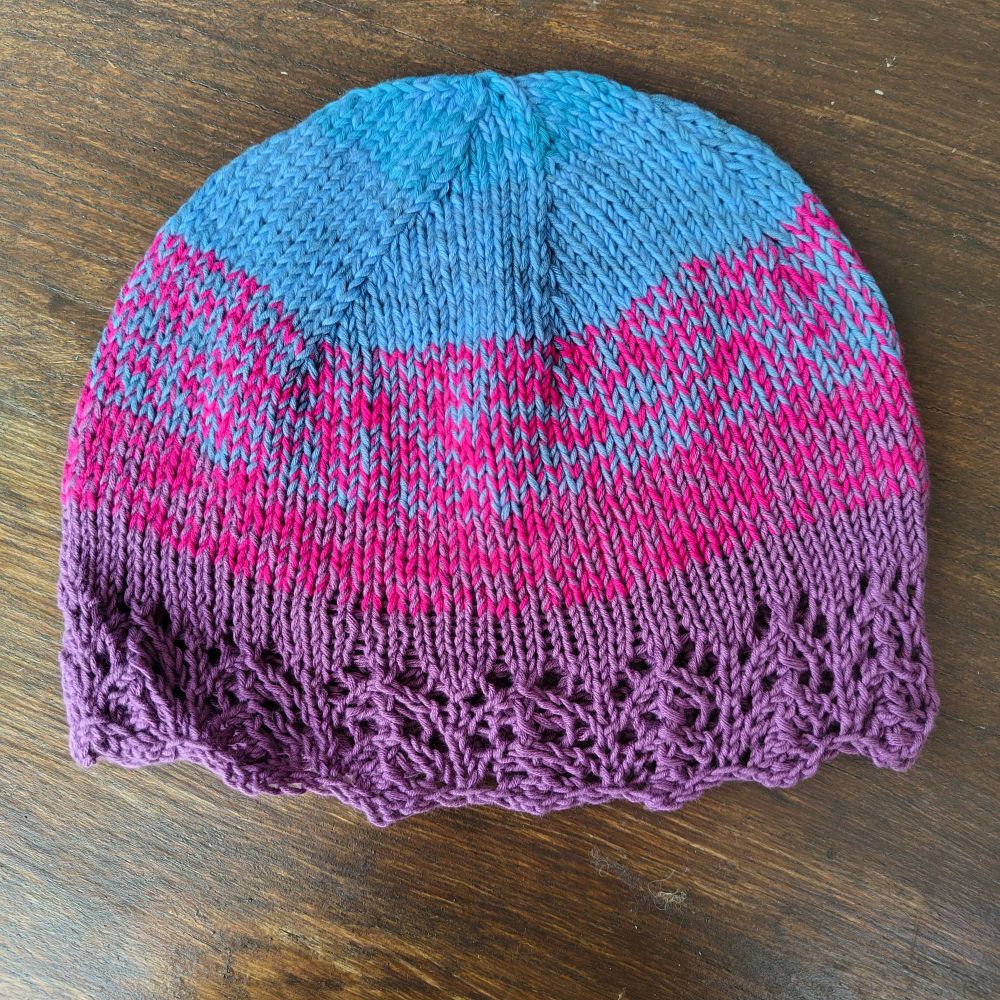 Beanie hat in purple, pink (which is marled with the other colours) & blue.