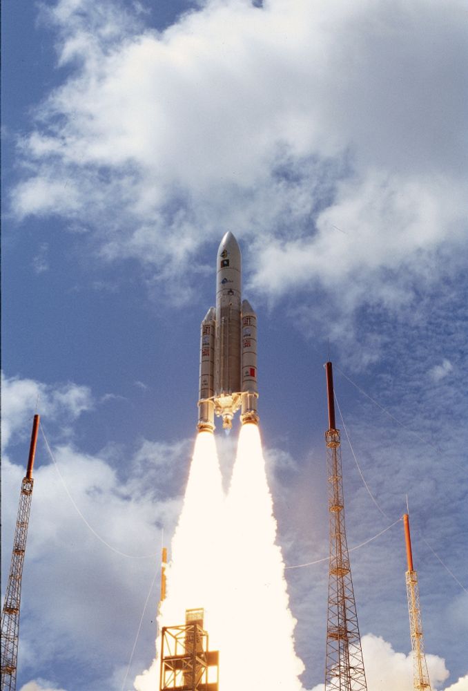 Lancio dell'Ariane 5 V112. Su un cielo azzurro con alcune nuvole bianche, il lanciatore si è appena staccato dal suolo. 