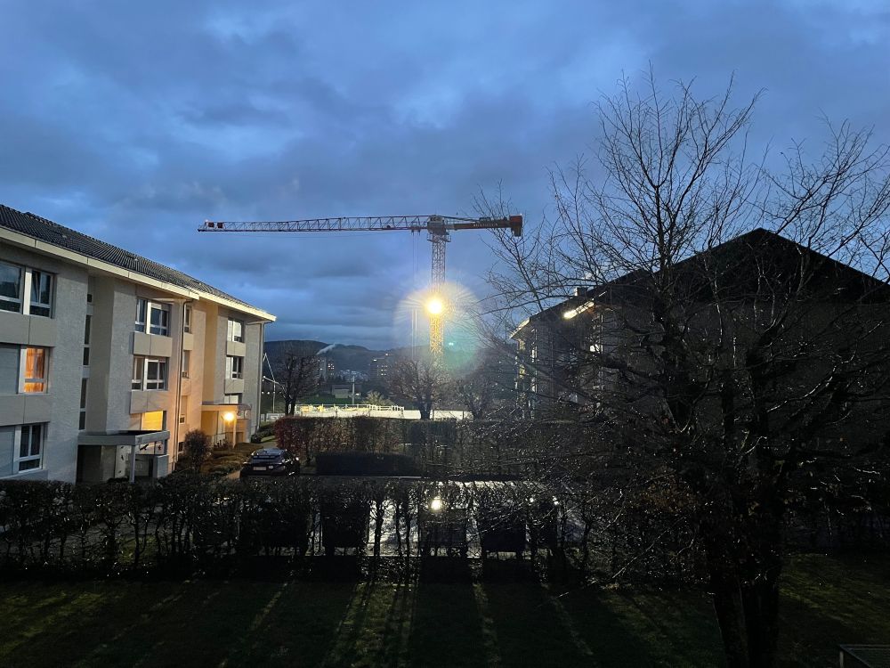 Bauscheinwerfer am Kran erleuchtet die Nachbarschaft