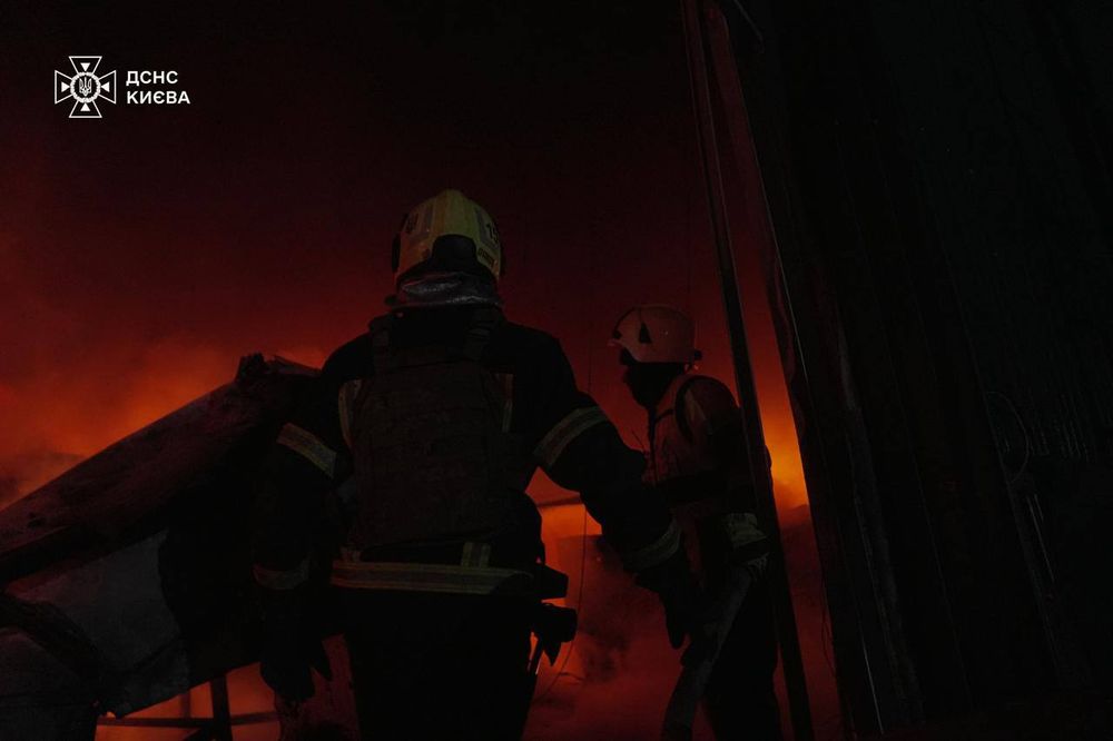 Emergency workers in a fire after Russian missile attack in Kyiv.