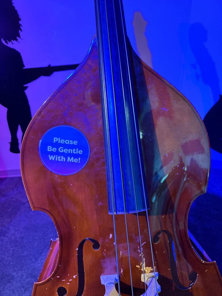 Double bass with a sticker on it that says “Please be gentle with me.”