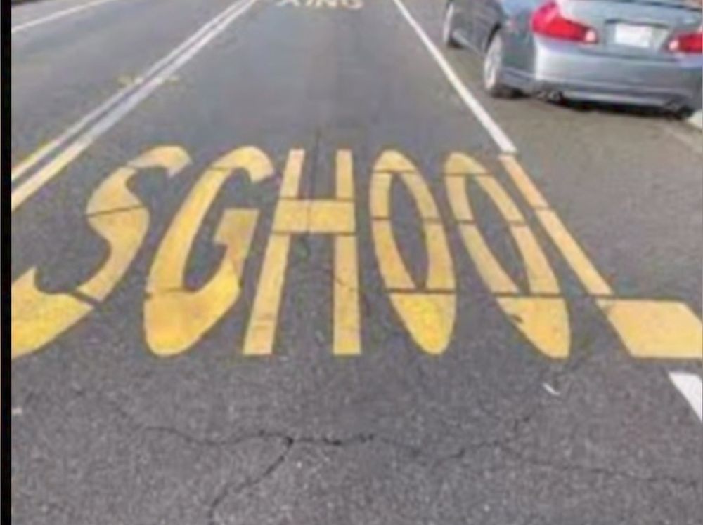 "school" escrito no asfalto mas com um gê no lugar do cê