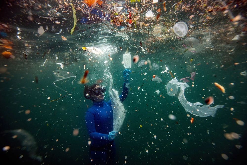 A diver surrounded by plastic garbage.