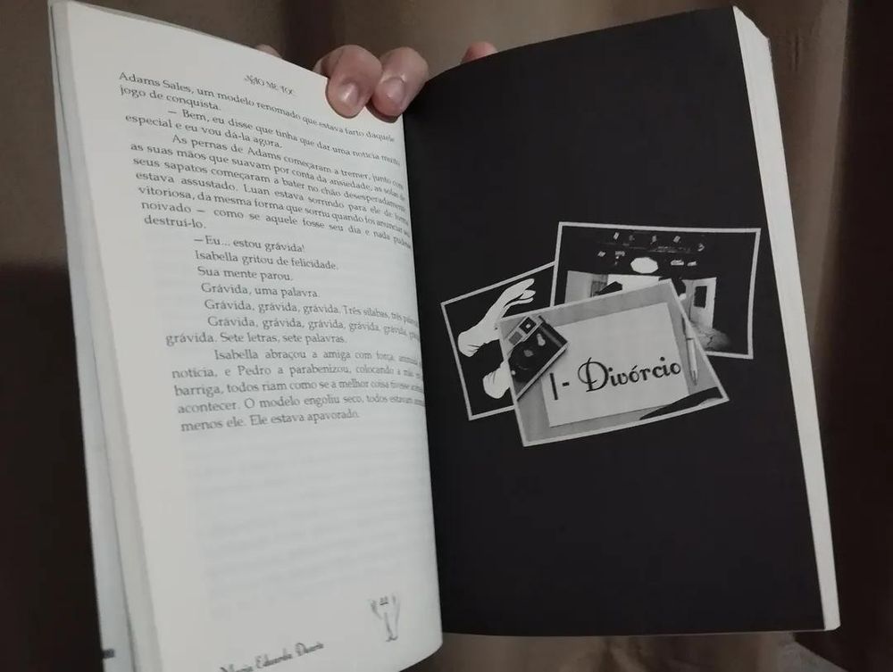 Livro aberto com página preta, o preto não está tão chapado, e a página com texto é um pouco transparente. 