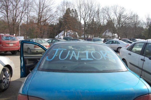 Electric blue car with "JUN10RS" written in chalk paint on the rear window. 