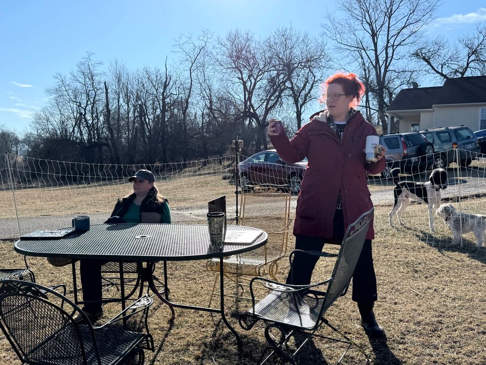 People gathering at a table in a barnyard