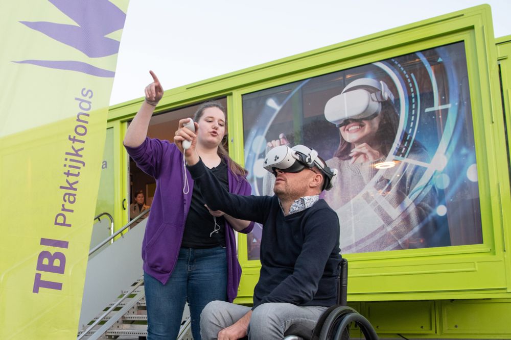 Op de foto zie je mij voor de Zorg & Welzijn truck staan. Ik heb een VR-bril op. Ik krijg uitleg hoe het werkt. 