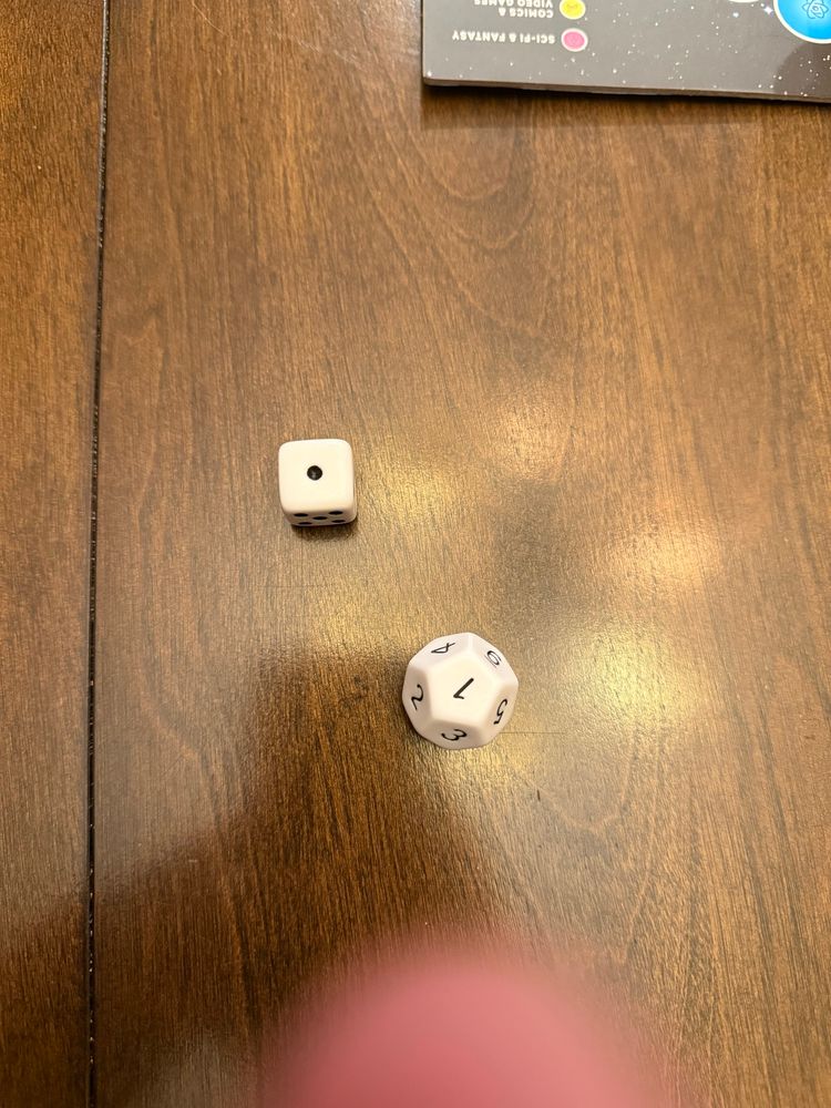 Six and twelve sided dice both showing the number one. 