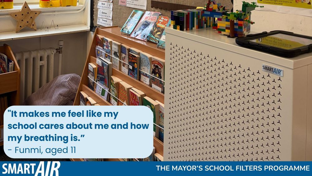 A Smart Air Blast air purifier is placed in the reading corner of a primary school classroom. Bookshelves filled with children’s books and colourful learning posters are displayed on the walls. A quote on screen reads, “It makes me feel like my school cares about me and how my breathing is.” – Funmi, aged 11. The image promotes The Mayor’s School Filters Programme.