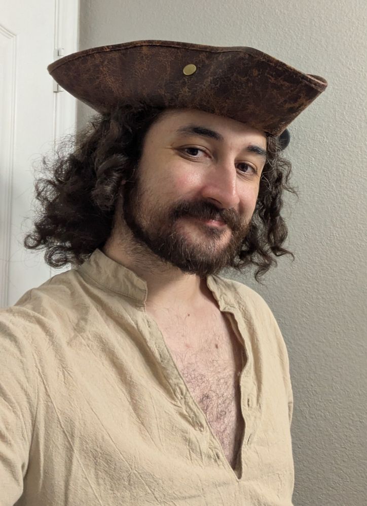 A selfie of me dressed as a pirate. I've got a hat on and my hair is spilling out the sides.