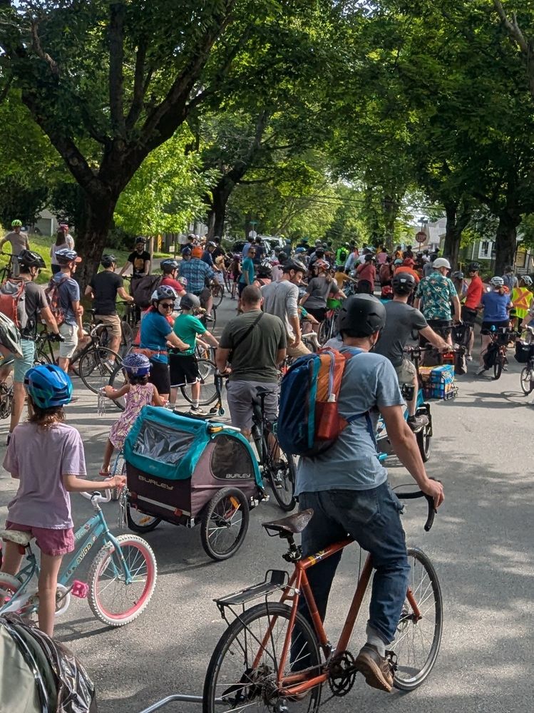 Kidical mass as seen from near back of the pack about to roll out from Ardmore park. The street is nearly full of people of various ages on bikes
