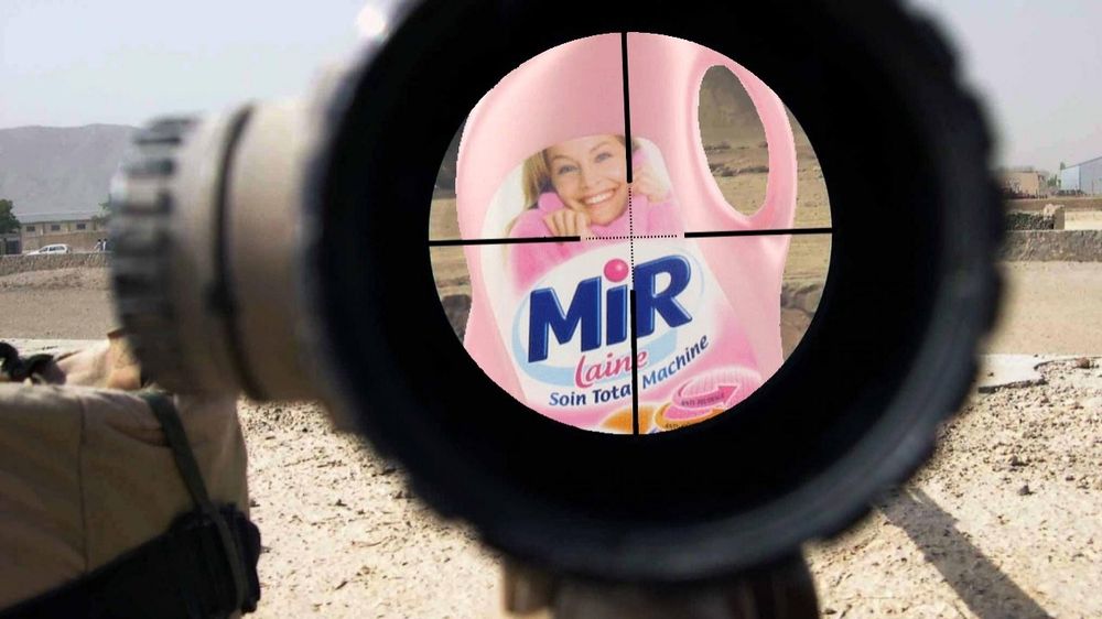 Une lunette de fusil vise un flacon de lessive Mir