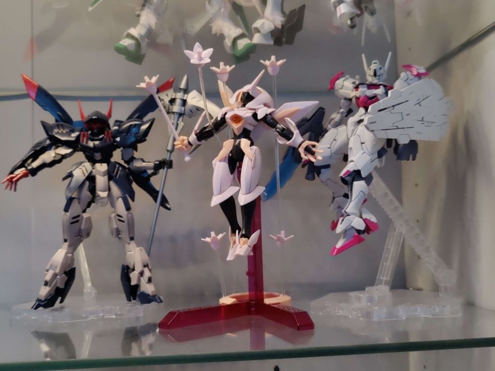 a photo of a completed gundam hg fawn farcia next to a hg gremory and hg lfrith.