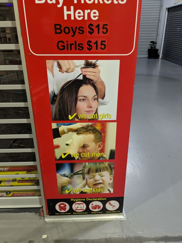 advertising sign for a haircut place which says "we cut girls, we cut men, we cut kids". the child pictured on the sign looks particularly distressed.