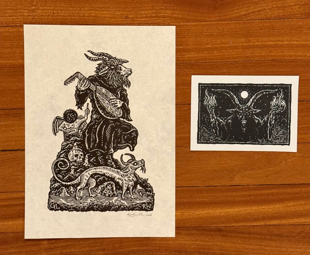 Print of a goat headed creature playing the lute and smaller card of a goat headed demon holding two torches.