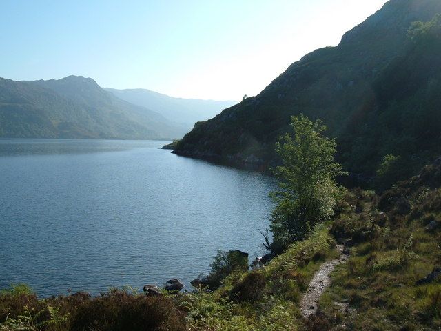 Loch Morar, framed by wooded mountains.