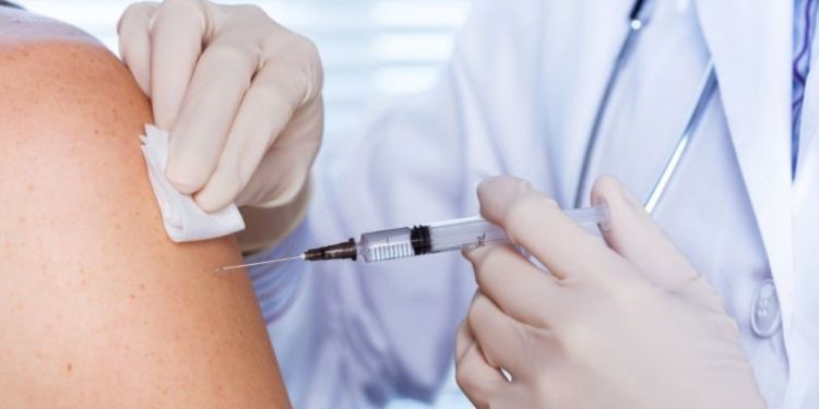 A vaccine is administered to a patient in their arm.