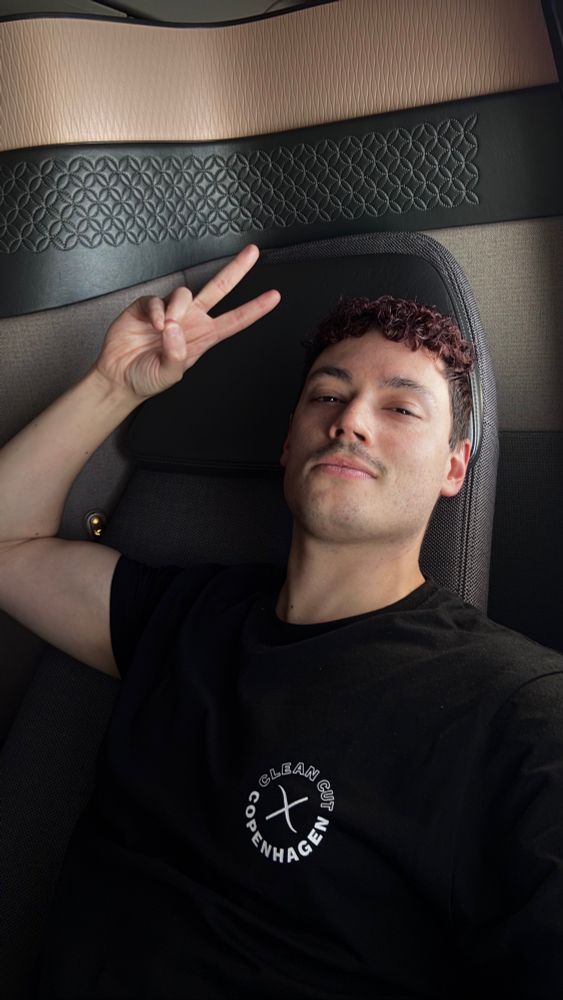 Me holding up a peace sign in business class