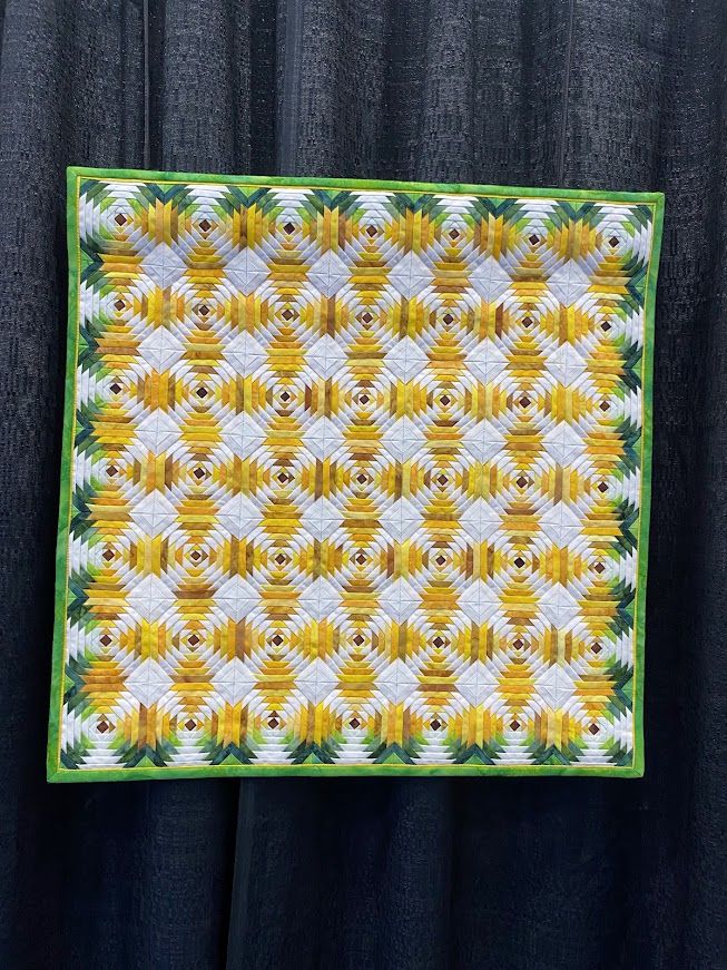 A teeny tiny quilt of unbelievable complexity and precision. A log cabin in whites and greens and yellows in 49 blocks.  

Perseverance by Janet Smith
Woodway, TX
USA
Techniques: Machine piecing and quilting; paper piecing
Design Source: Miniature Quilts by Kumiko Frydl, publication date 2012 (France) and 2018 (Great Britain)
My Grandmother Beck made beautiful quilts by hand, and she taught me to sew and piece. She never entered a quilt show. This quilt was a struggle to get through. It has 2,401 quarter-inch pieces, and any time I thought about quitting, I could hear her say, "Don't waste fabric, and do a good job."
Thanks, Grandma.