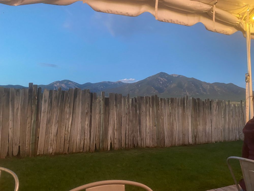 A picture that does no justice whatsoever ever to Taos Mountain at dusk taken from the patio of a pizza place. 