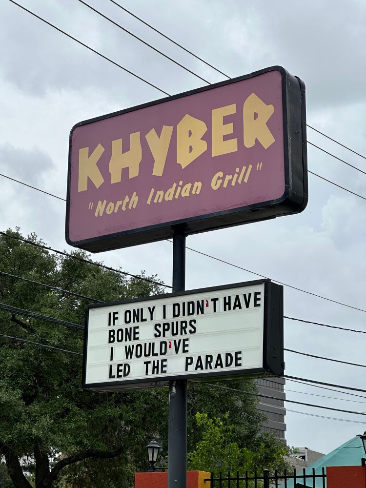 A sign on the Khyber Indian restaurant. 

The message is “if only I didn’t have bone spurs I would’ve led the parade.”
