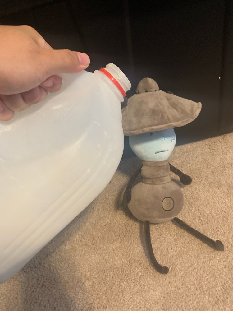 A plush of Airy from HFJONE, and a large carton of milk about to be poured onto him