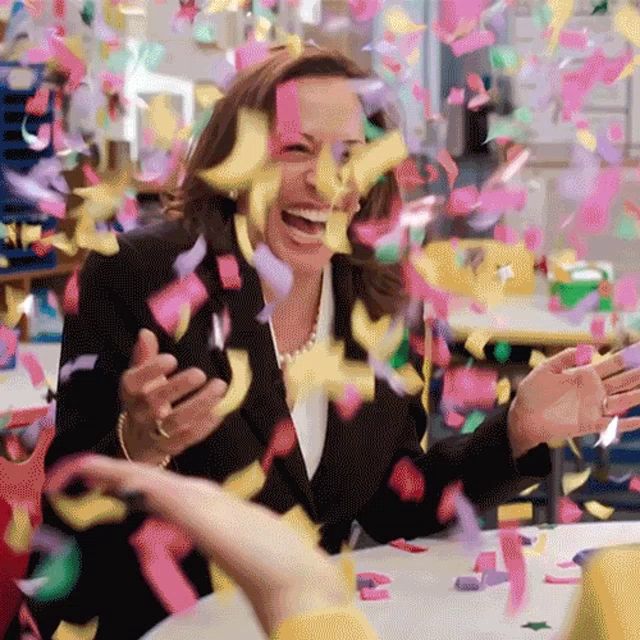 a woman is surrounded by confetti while sitting at a table