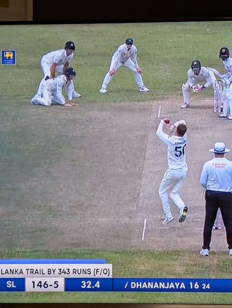 Cricket player fielding on hands and knees.