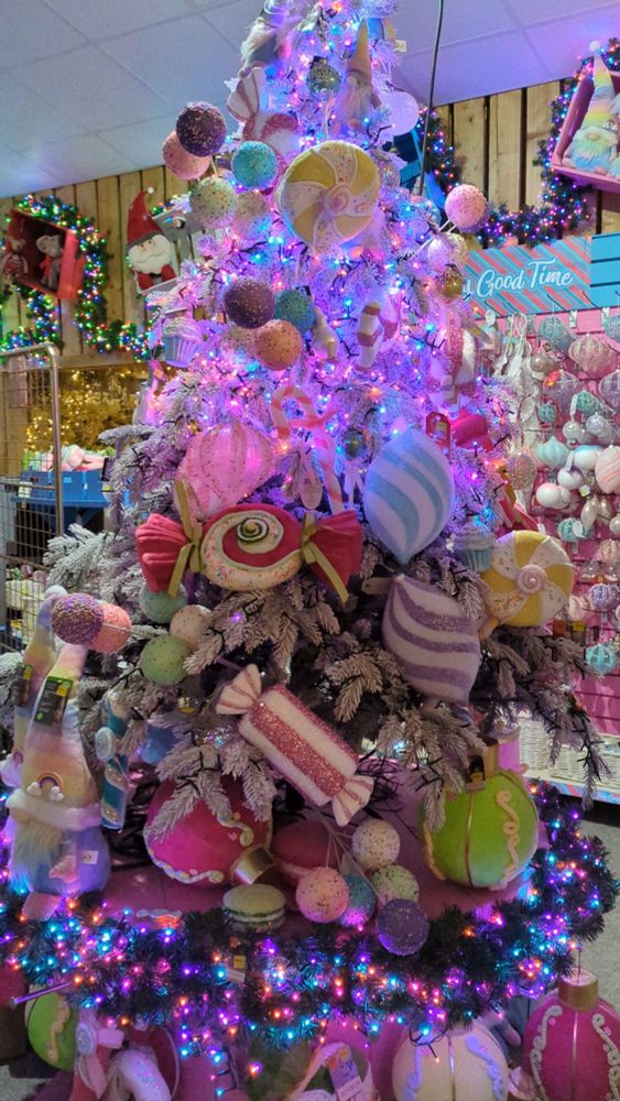 A pink Christmas tree decorated with candy themed accessories 