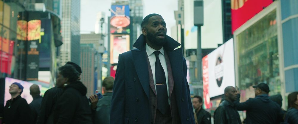 Colman Domingo stands in Times Square and looks at something out of frame.