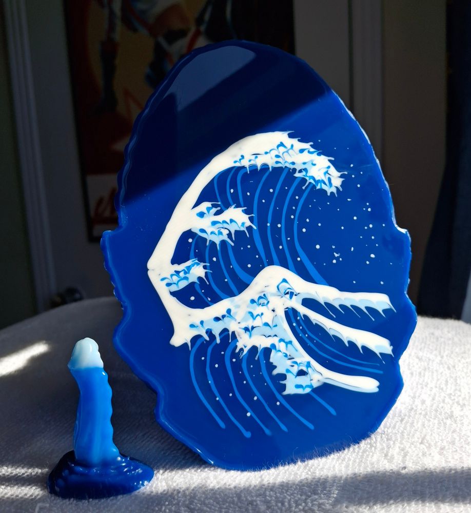 Kisu and Friends signature Great Wave pour on a large Rhei adult toy. A matching miniature Rhei is on its left. Direct sunlight used to show the detail on the hand painted wave.