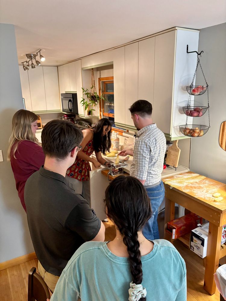 Five lab members rolling out fresh pasta dough