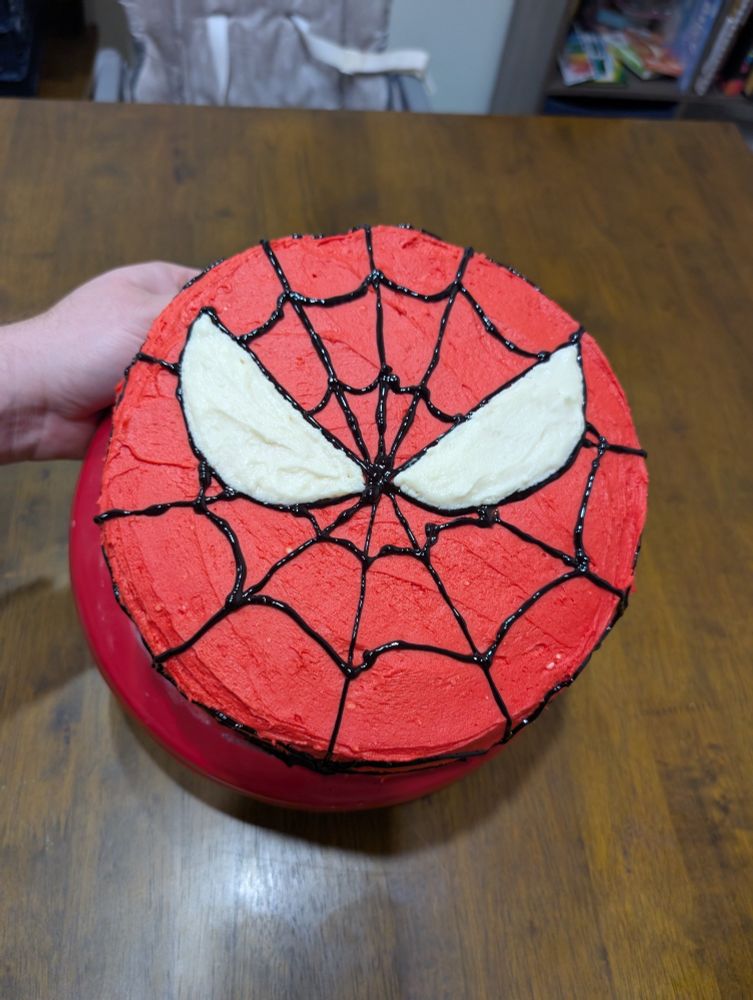 Circle cake with red background and Spiderman mask